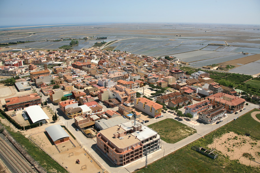 Vista aèria d'un poble del Baix Ebre envoltat d'arrossars i canals del Delta
